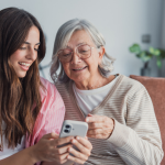 Why digital services are essential to modern housing management - people smiling using phone at home